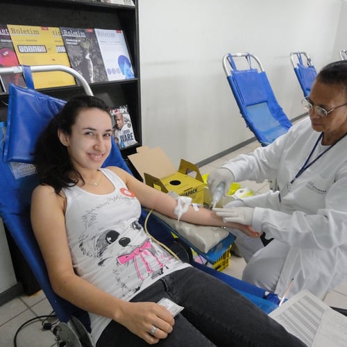 Mulher sorri enquanto tira sangue no Hemominas (Foto: Agência Minas Gerais)